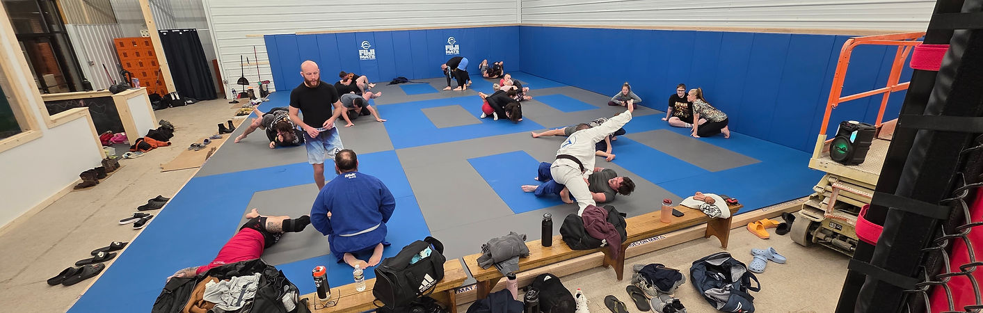 Students training Brazilian Jiu-Jitsu on blue and gray mats at Sonic